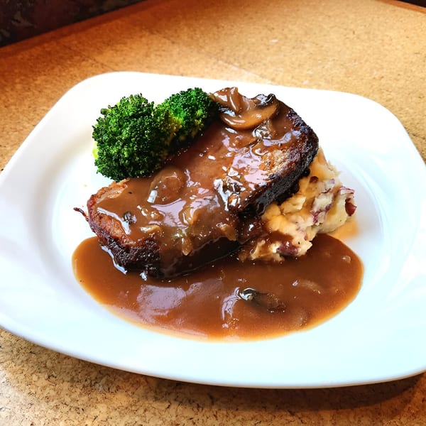 Meatloaf with mushroom gravy, mashed potatoes, and broccoli on a white plate at Wasena City Tap Room.